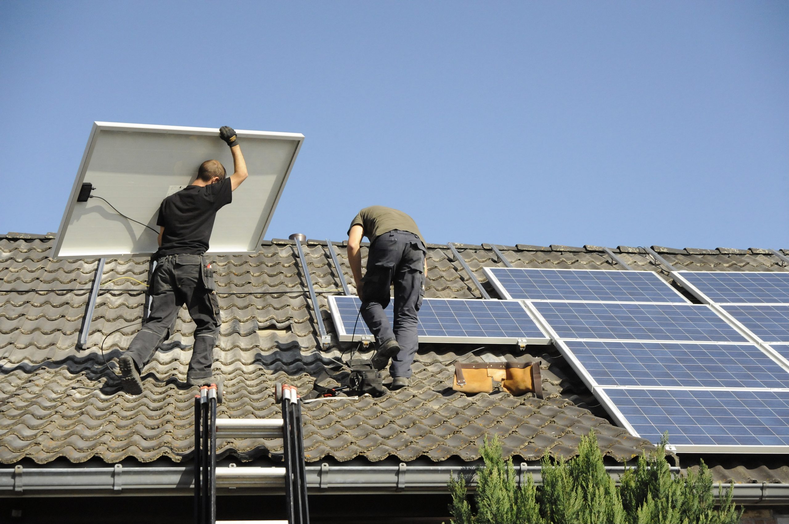 experts dcme posant des panneaux photovoltaïque sur le toit en tuile d'une maison