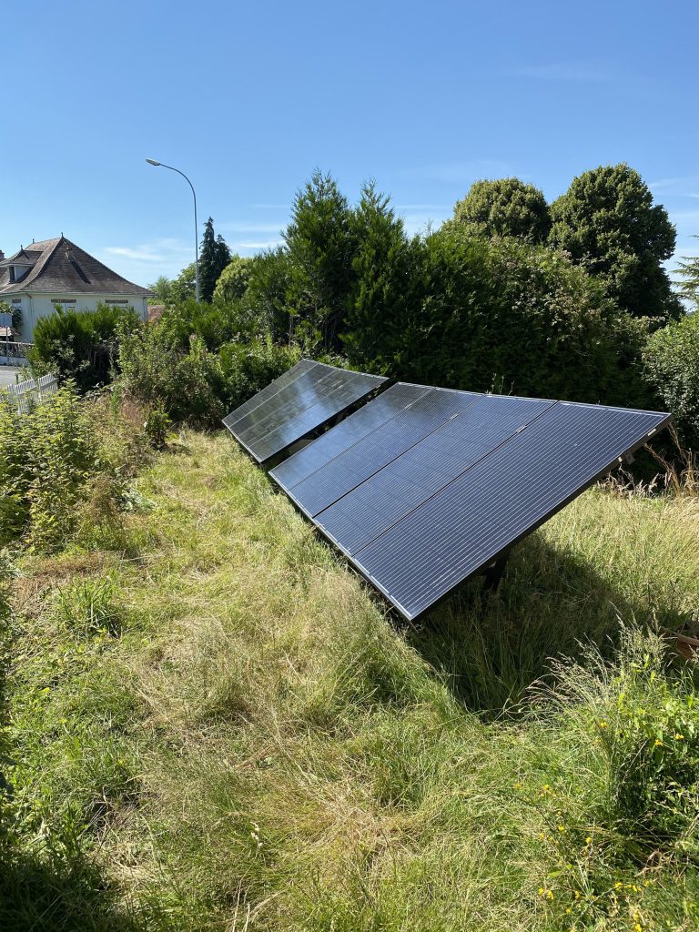 installation de panneaux solaires hybrides au sol dans le jardin d'une maison individuelle